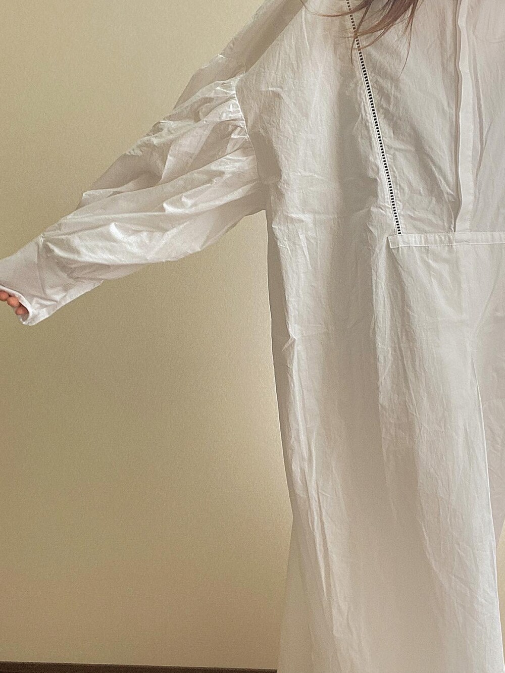 ホワイト系のシャツワンピース、ブラック系のブーツを着用したレディースの冬コーディネートの2枚目の写真