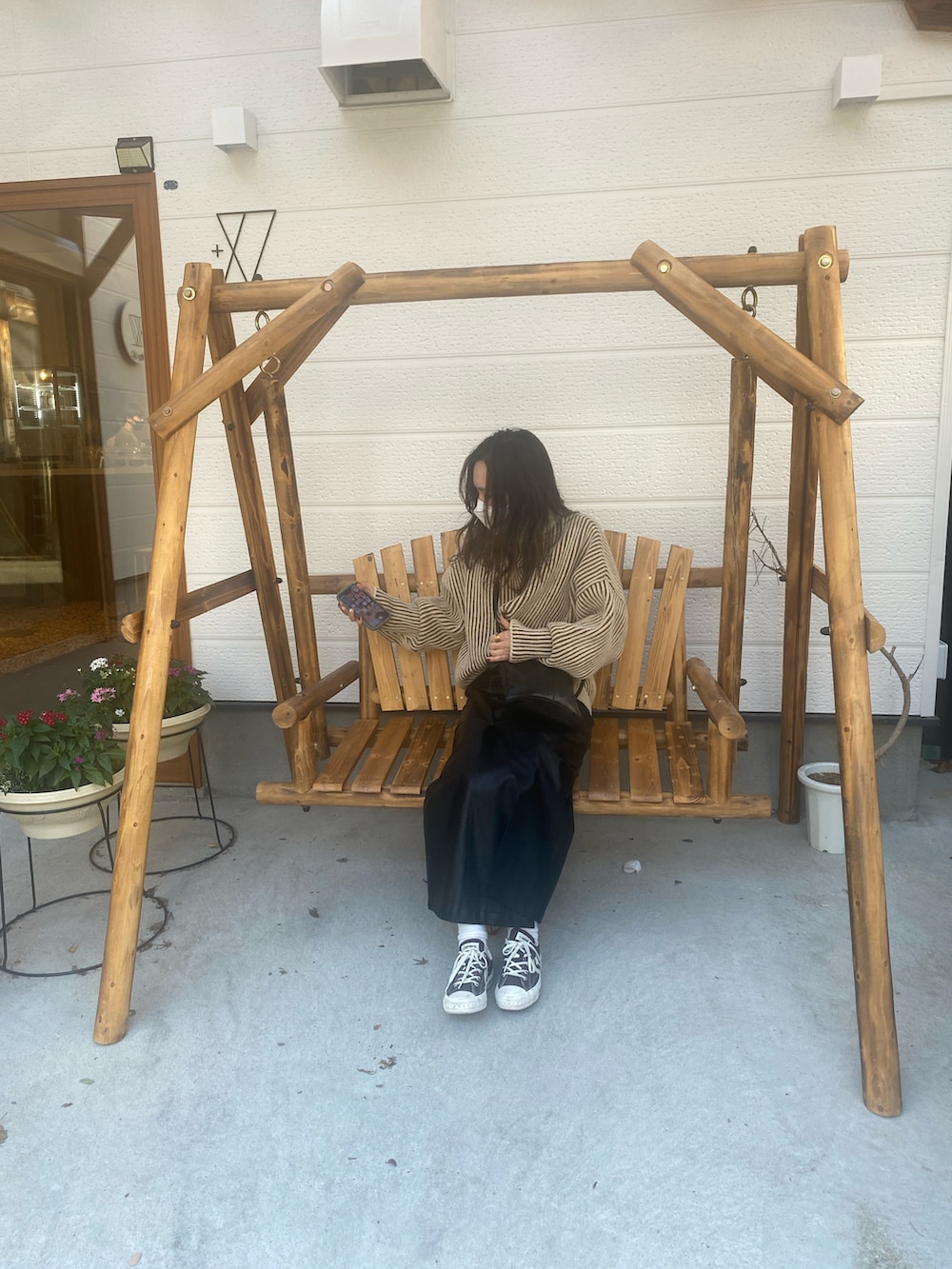 ブラウン系のニット/セーター、ブラック系のスカート、ブラック系のショルダーバッグを着用したレディースの秋コーディネートの2枚目の写真