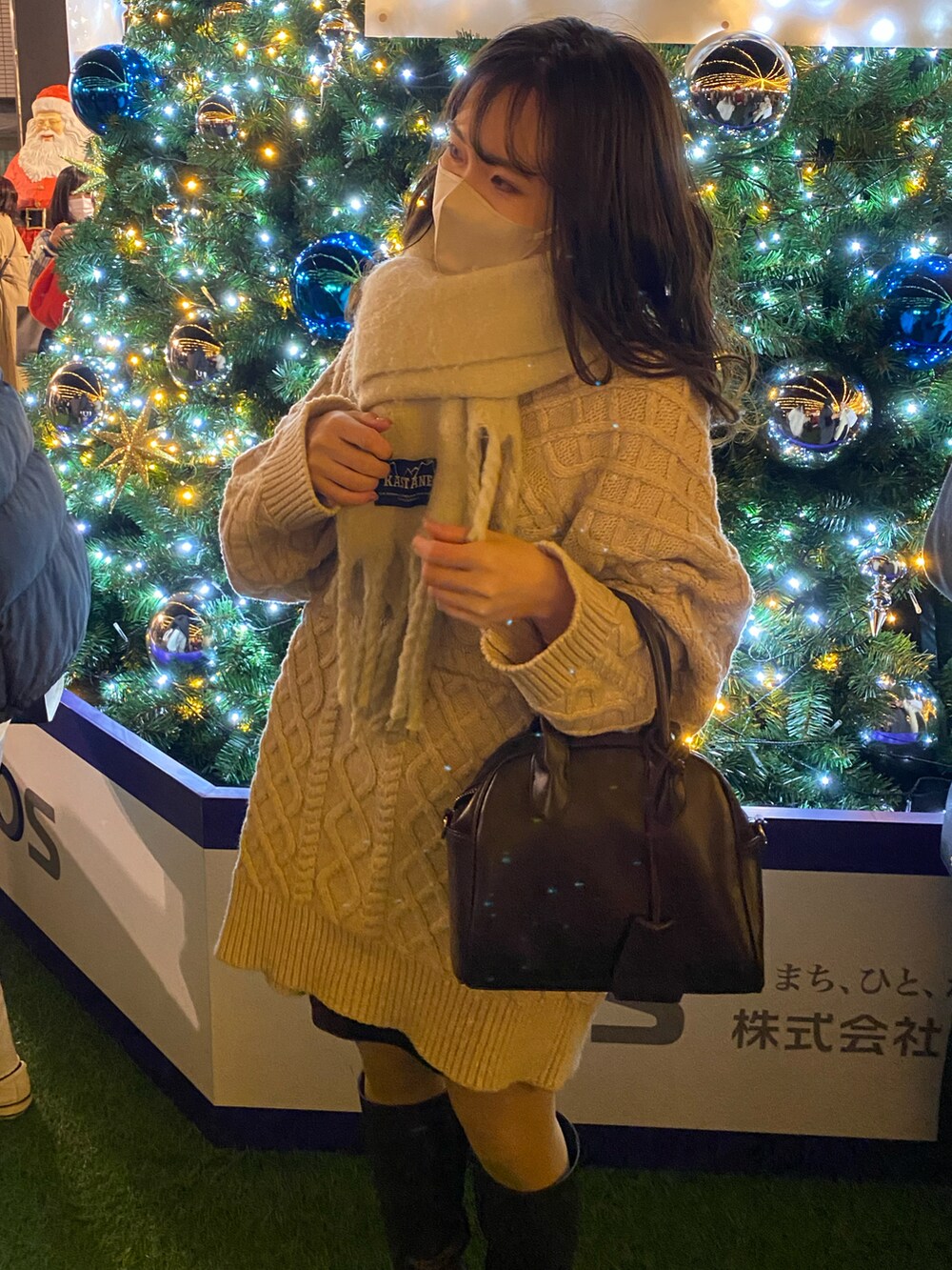 ブラウン系のブーツ、ブラウン系のボストンバッグ、ホワイト系のニット/セーターを着用したレディースの冬コーディネートの5枚目の写真