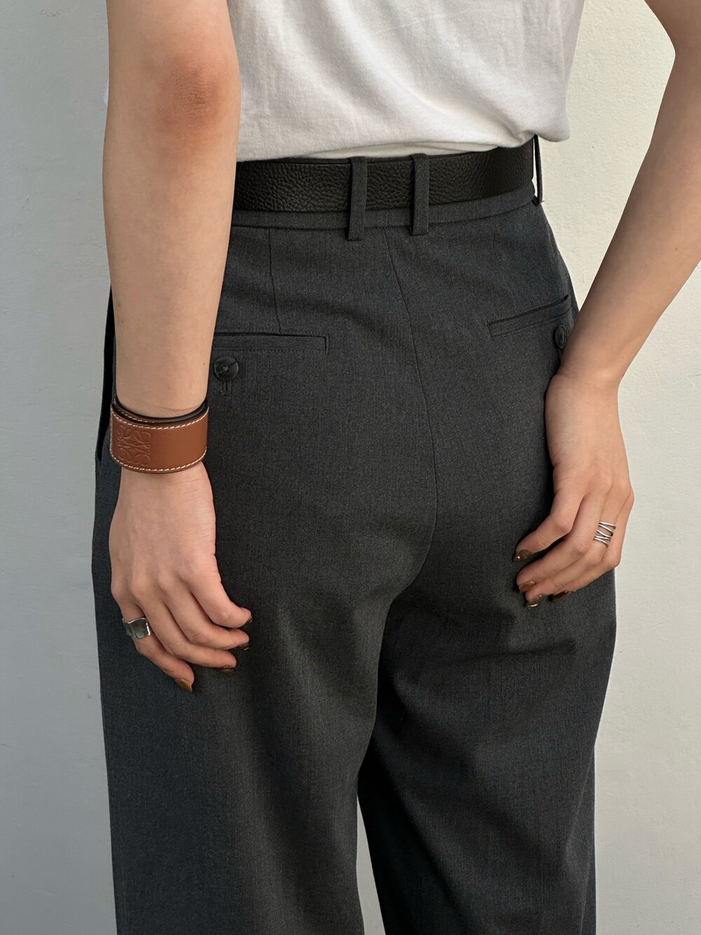 ブラック系のサンダル、グレー系のパンツ、ブラック系のベルトを着用したレディースの夏コーディネートの4枚目の写真