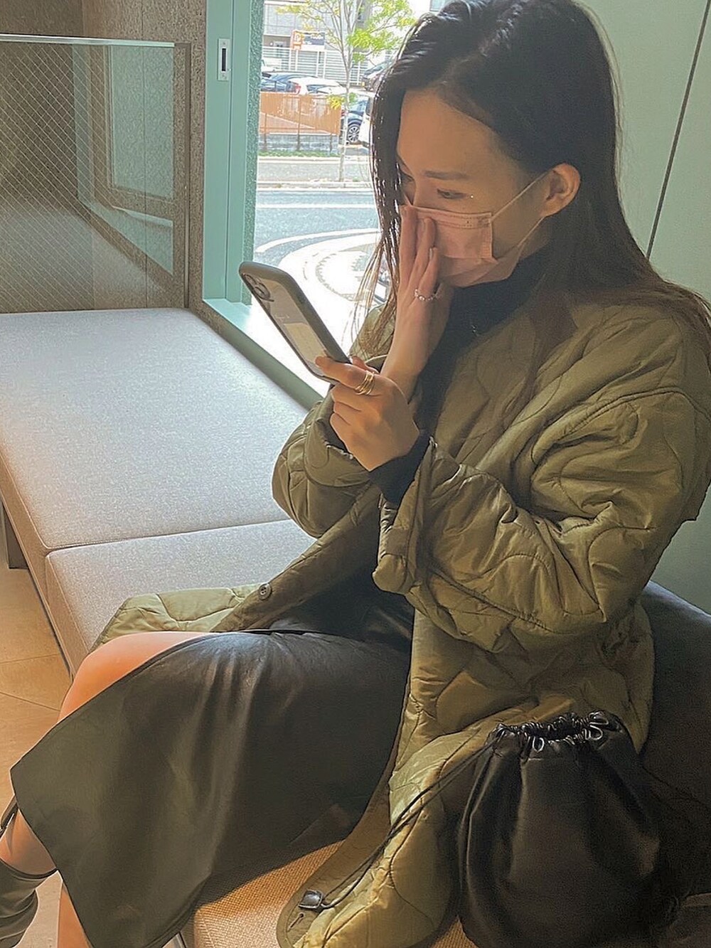 グリーン系のノーカラージャケット、ブラック系のスカート、ブラック系のショルダーバッグを着用したレディースの冬コーディネートの2枚目の写真