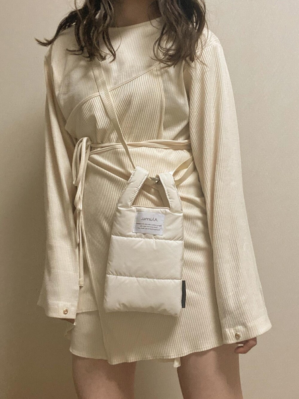 ベージュ系のトップスを着用したレディースの春コーディネートの2枚目の写真