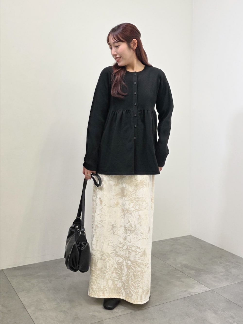 ブラック系のブルゾン、ホワイト系のスカート、ブラック系のチュニックを着用したレディースの冬コーディネートの2枚目の写真