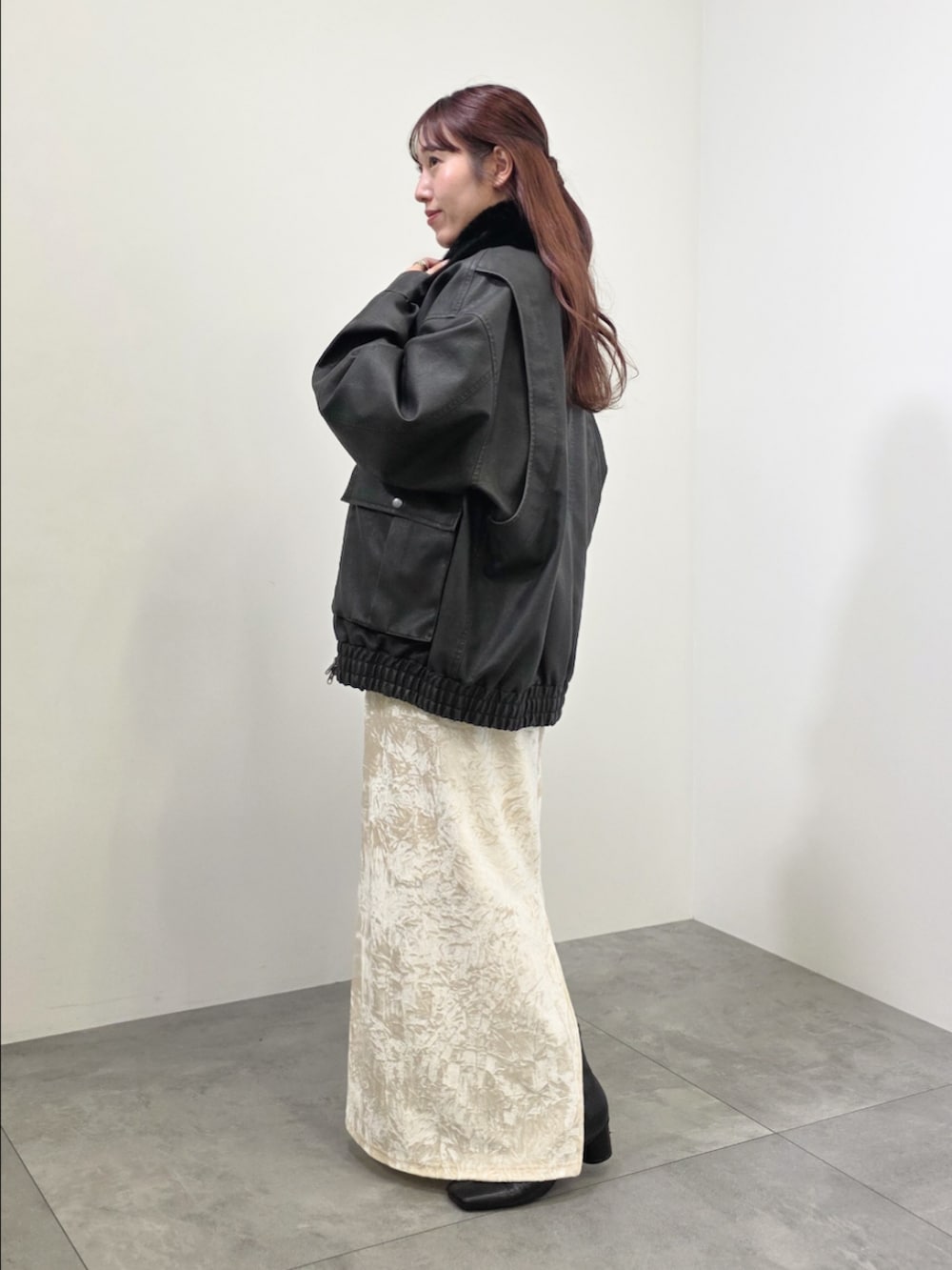 ブラック系のブルゾン、ホワイト系のスカート、ブラック系のチュニックを着用したレディースの冬コーディネートの4枚目の写真