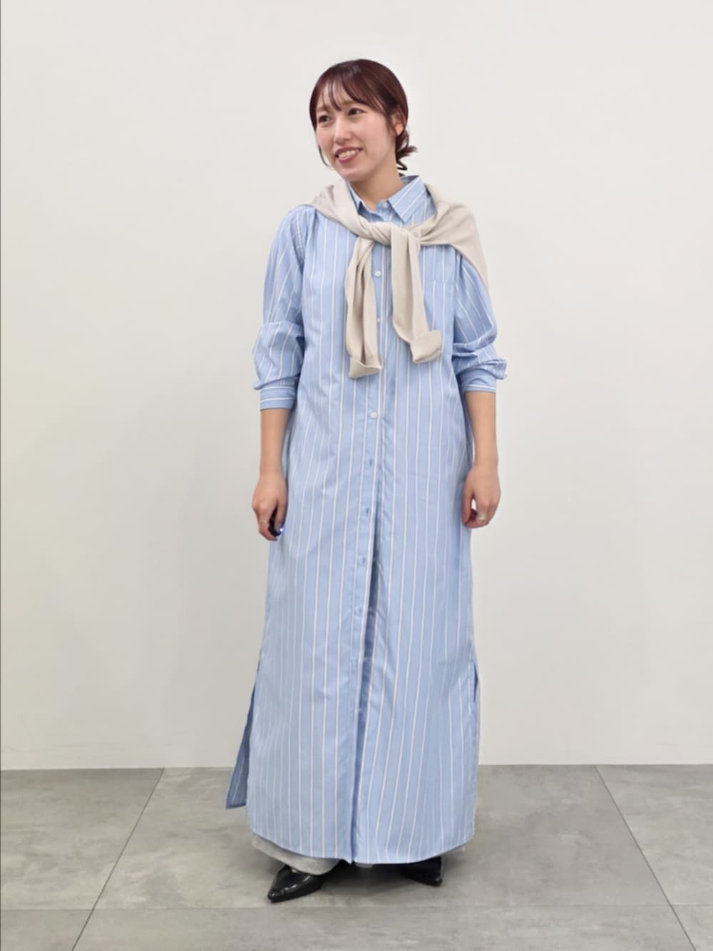 ブルー系のシャツワンピース、グレー系のスウェットパンツ、ベージュ系のニット/セーターを着用したレディースの春コーディネートの4枚目の写真