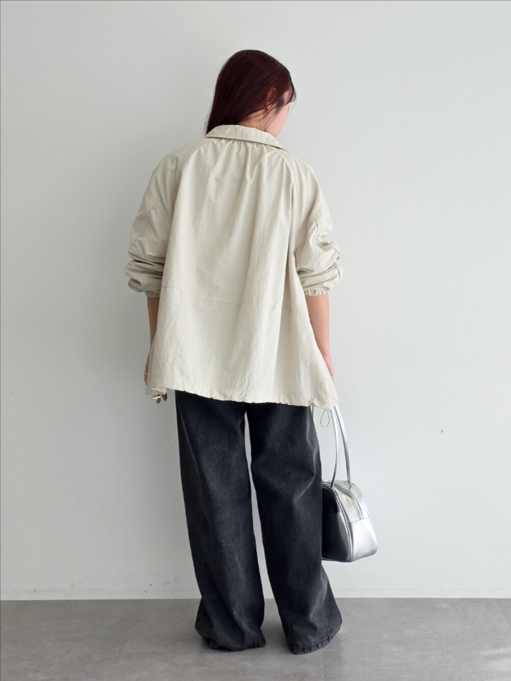 ベージュ系のブルゾン、レッド系のTシャツ/カットソー、グレー系のデニムパンツを着用したレディースの春コーディネートの3枚目の写真