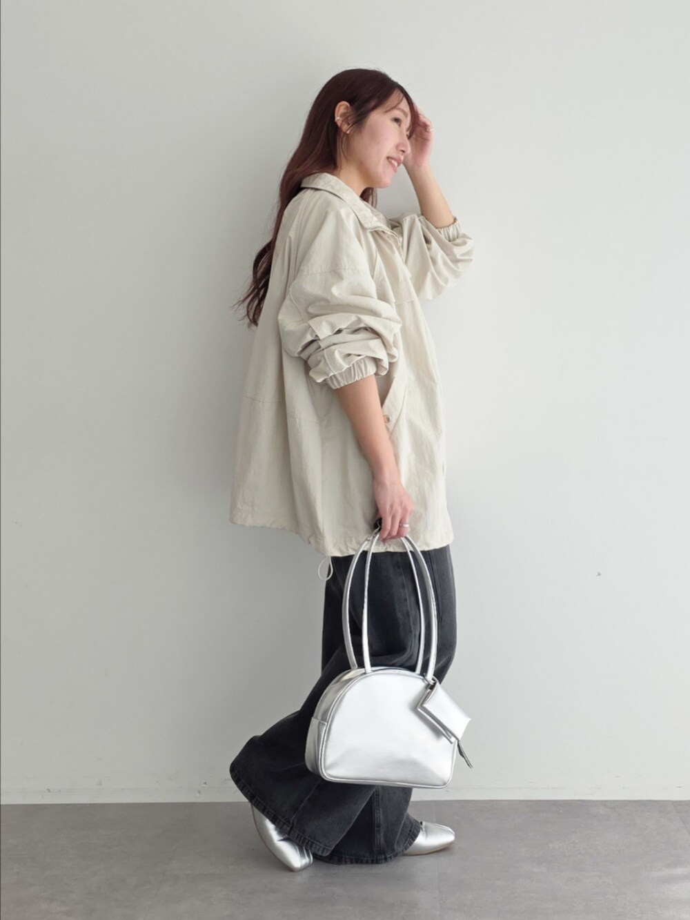 ベージュ系のブルゾン、レッド系のTシャツ/カットソー、グレー系のデニムパンツを着用したレディースの春コーディネートの2枚目の写真