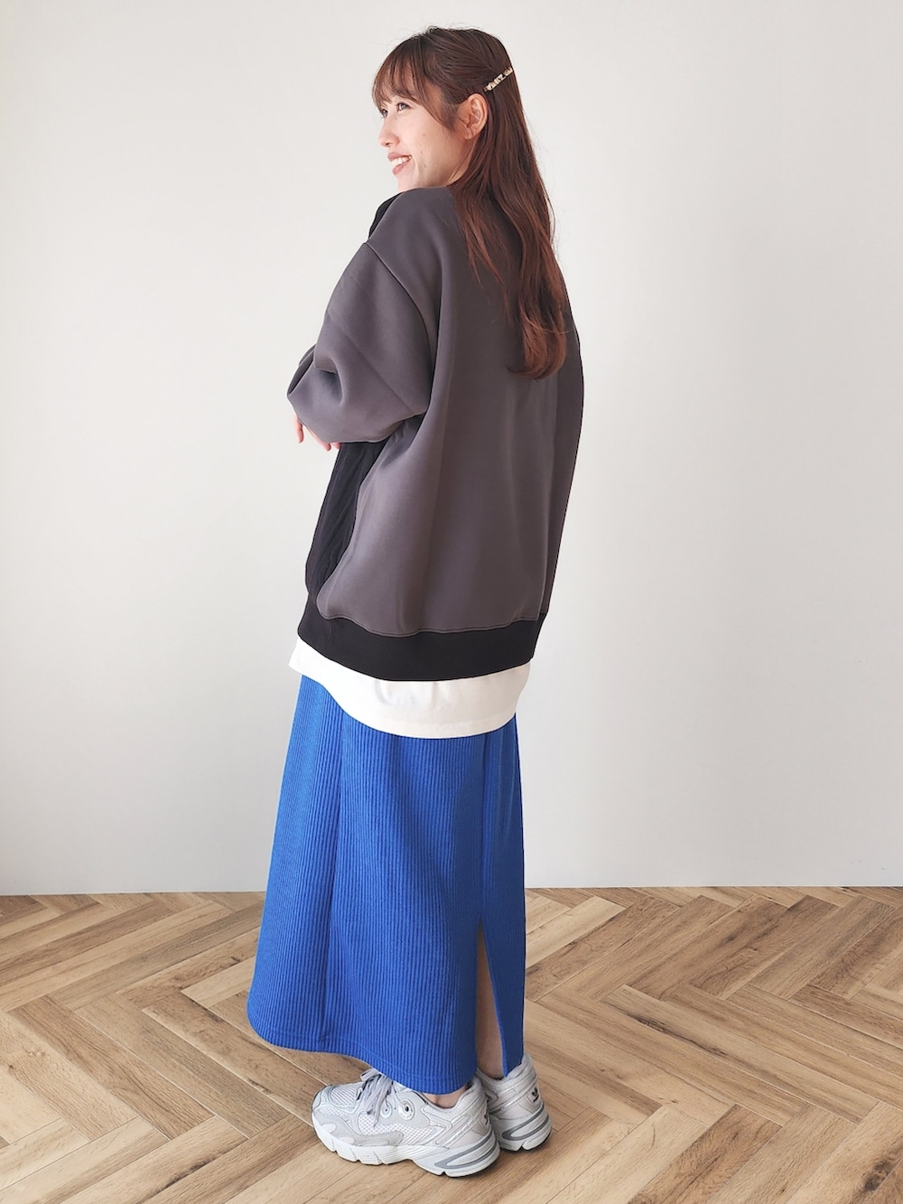 ブラック系のスウェット、ブルー系のスカートを着用したレディースの冬コーディネートの2枚目の写真