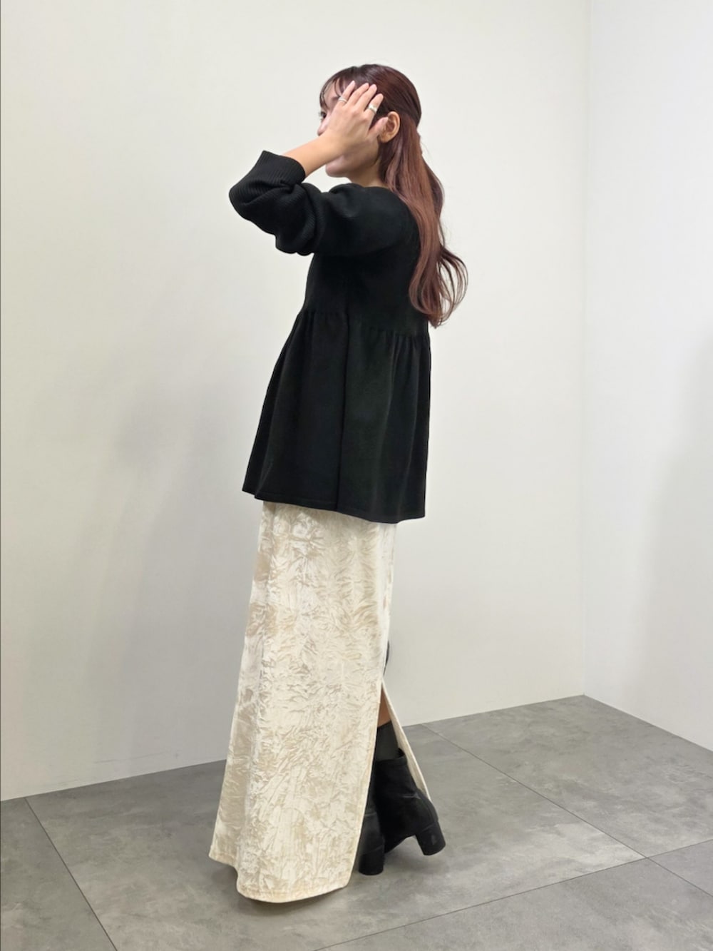 ブラック系のブルゾン、ホワイト系のスカート、ブラック系のチュニックを着用したレディースの冬コーディネートの3枚目の写真