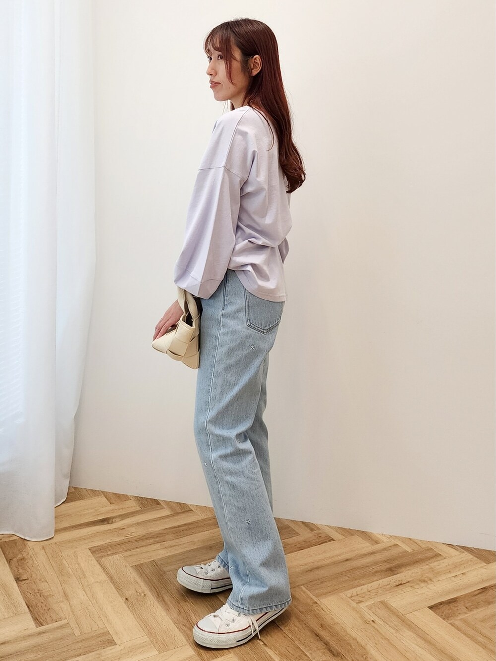 パープル系のTシャツ/カットソー、ホワイト系のショルダーバッグ、ブルー系のデニムパンツを着用したレディースの春コーディネートの2枚目の写真