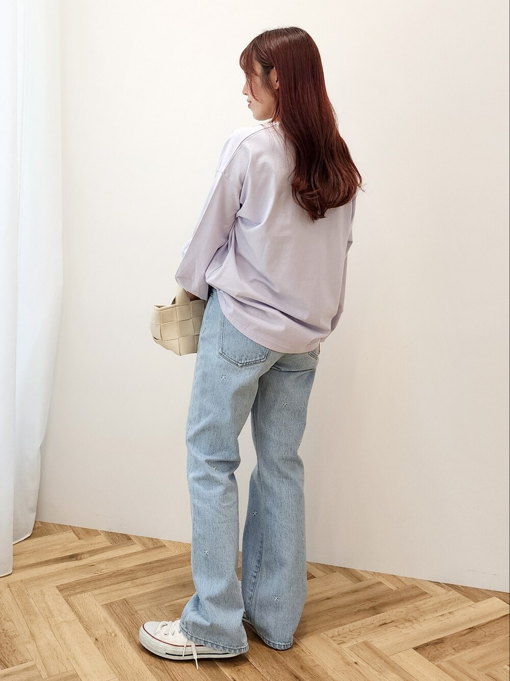 パープル系のTシャツ/カットソー、ホワイト系のショルダーバッグ、ブルー系のデニムパンツを着用したレディースの春コーディネートの3枚目の写真