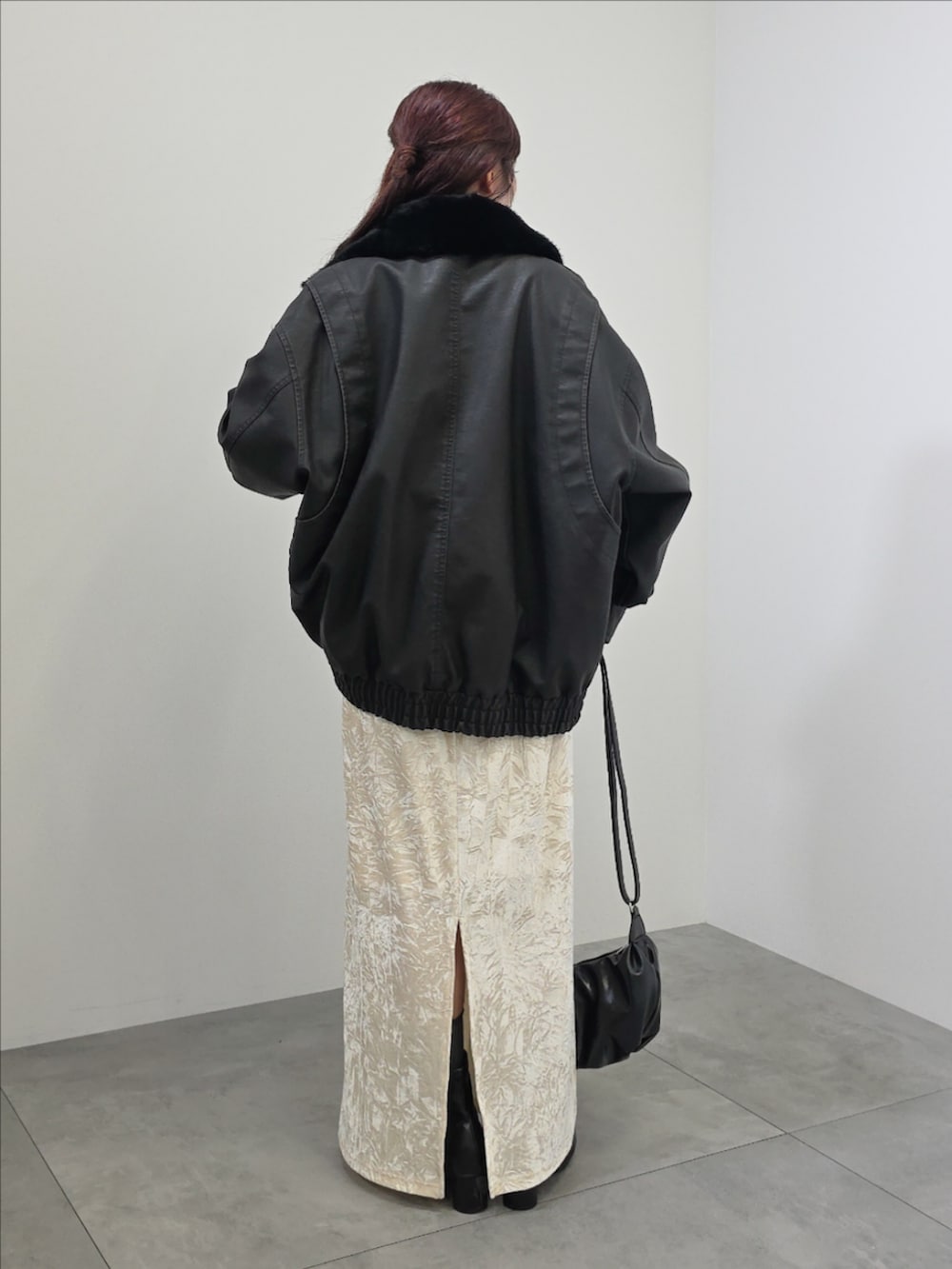 ブラック系のブルゾン、ホワイト系のスカート、ブラック系のチュニックを着用したレディースの冬コーディネートの5枚目の写真