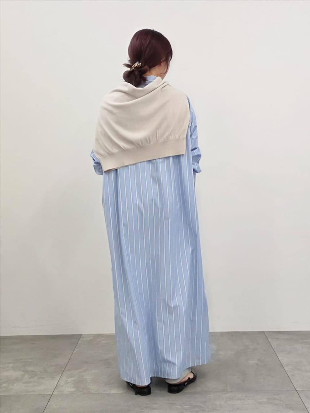 ブルー系のシャツワンピース、グレー系のスウェットパンツ、ベージュ系のニット/セーターを着用したレディースの春コーディネートの5枚目の写真