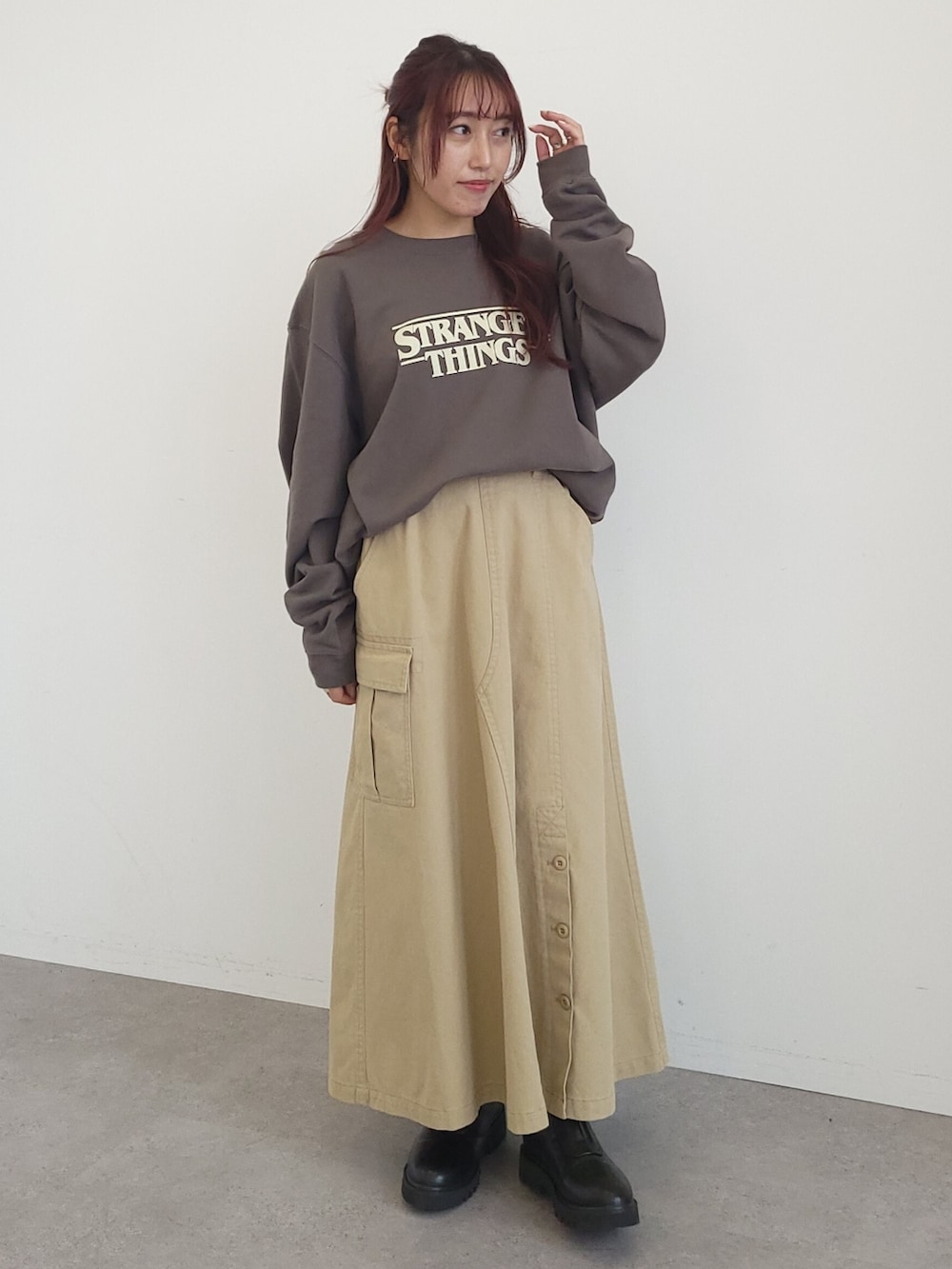 ベージュ系のスカート、グレー系のスウェット、ブラック系のブーツを着用したレディースの秋コーディネートの3枚目の写真