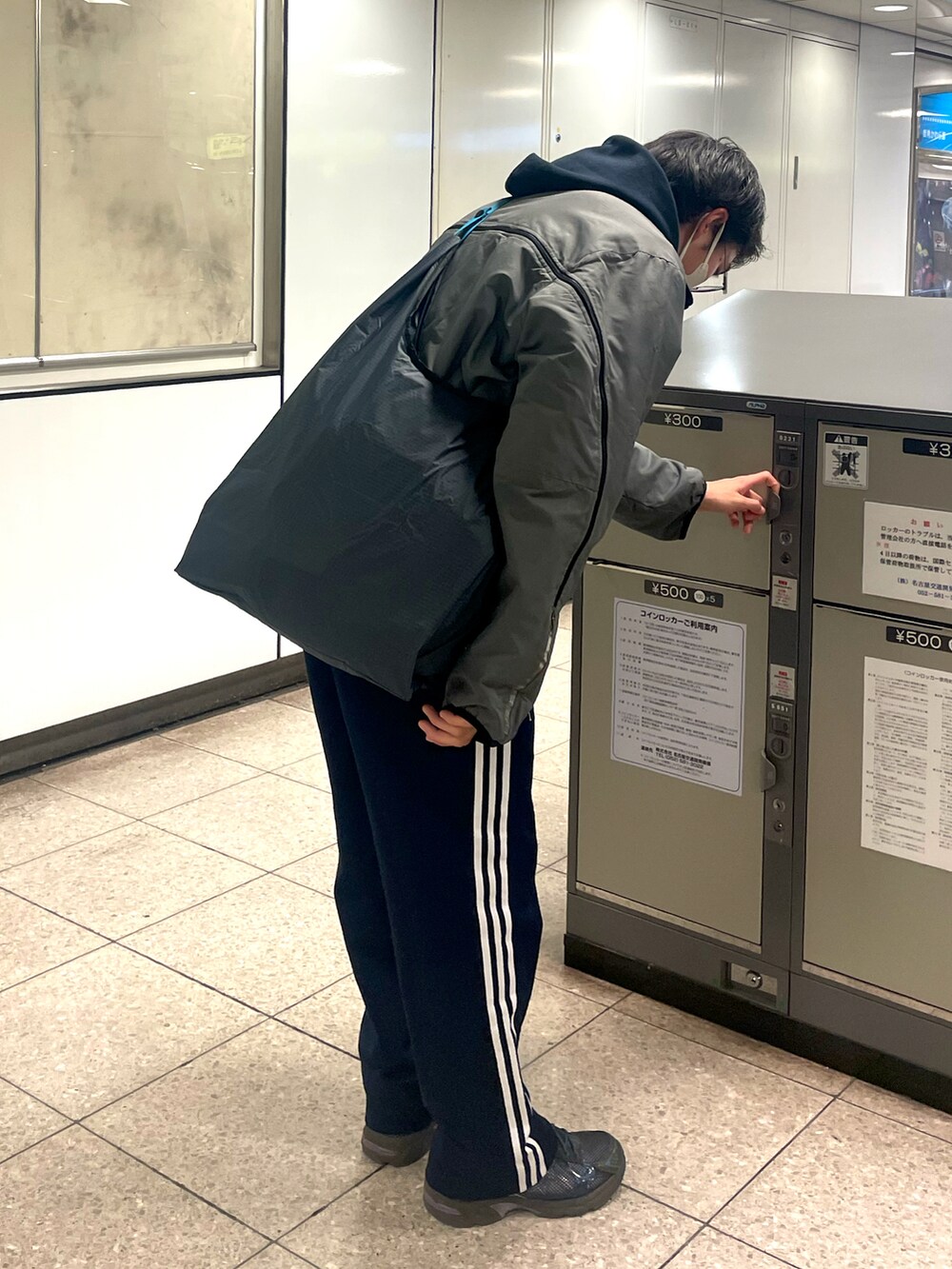 グレー系のジャケット/アウター、グレー系のショルダーバッグ、ブルー系のその他パンツを着用したメンズの冬コーディネートの2枚目の写真