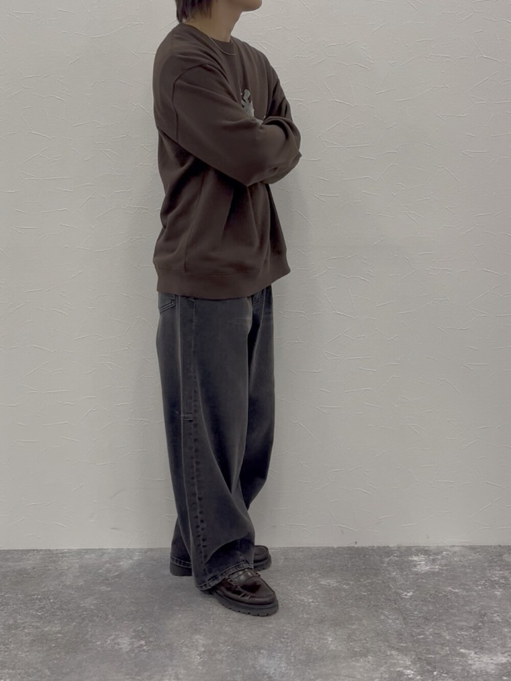 ブラウン系のスウェット、グレー系のデニムパンツ、ブラウン系のローファーを着用したメンズの秋コーディネートの5枚目の写真