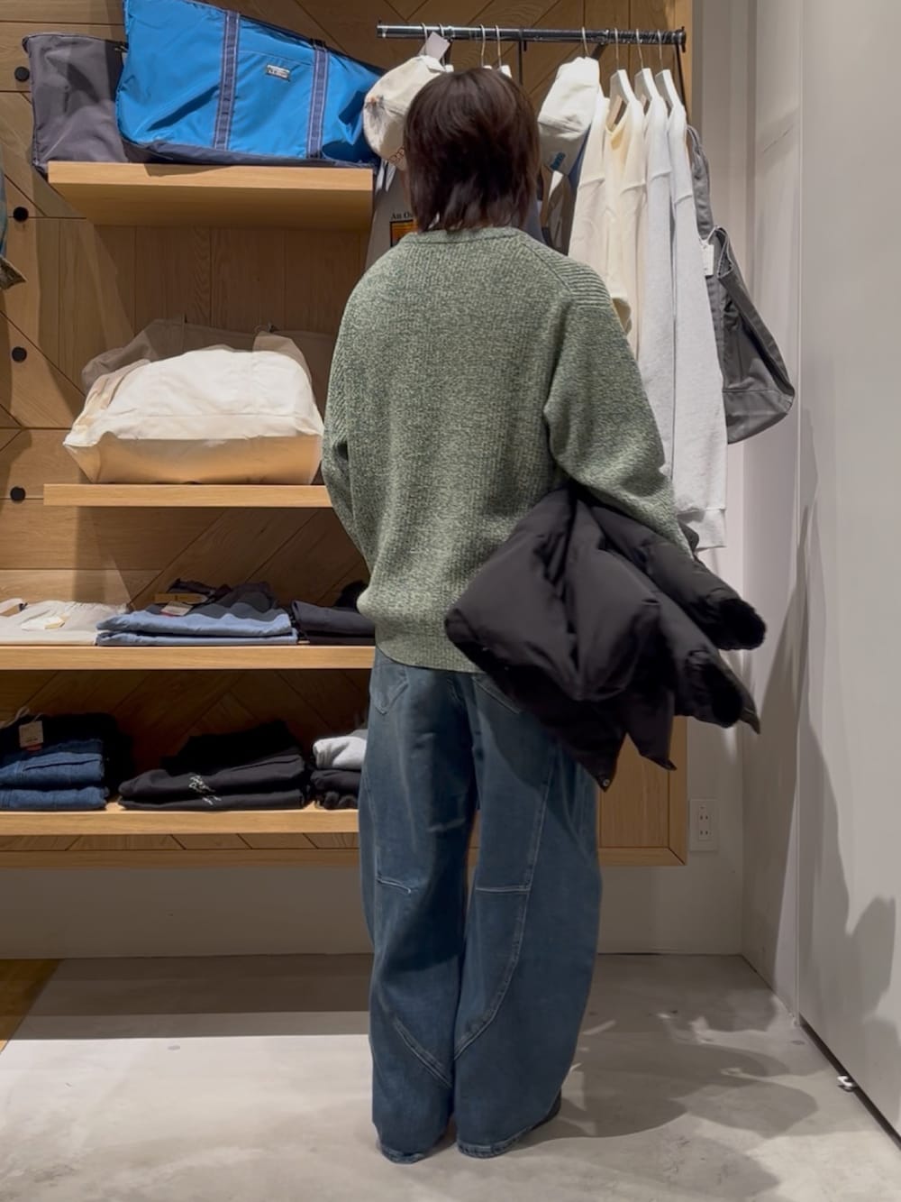 グリーン系のニット/セーター、ブラック系のブルゾン、ブルー系のデニムパンツを着用したメンズの冬コーディネートの4枚目の写真