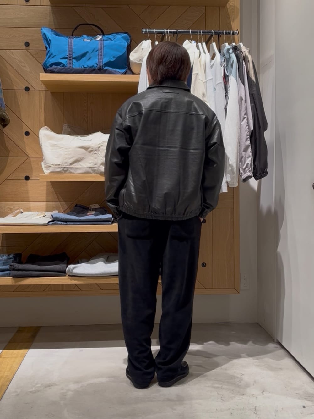 ブラック系のブルゾン、ブルー系のニット/セーター、ブラック系のその他パンツを着用したメンズの冬コーディネートの4枚目の写真