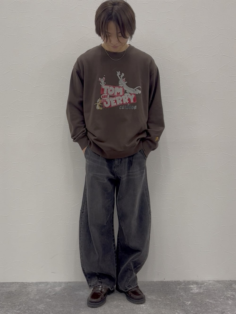 ブラウン系のスウェット、グレー系のデニムパンツ、ブラウン系のローファーを着用したメンズの秋コーディネートの2枚目の写真