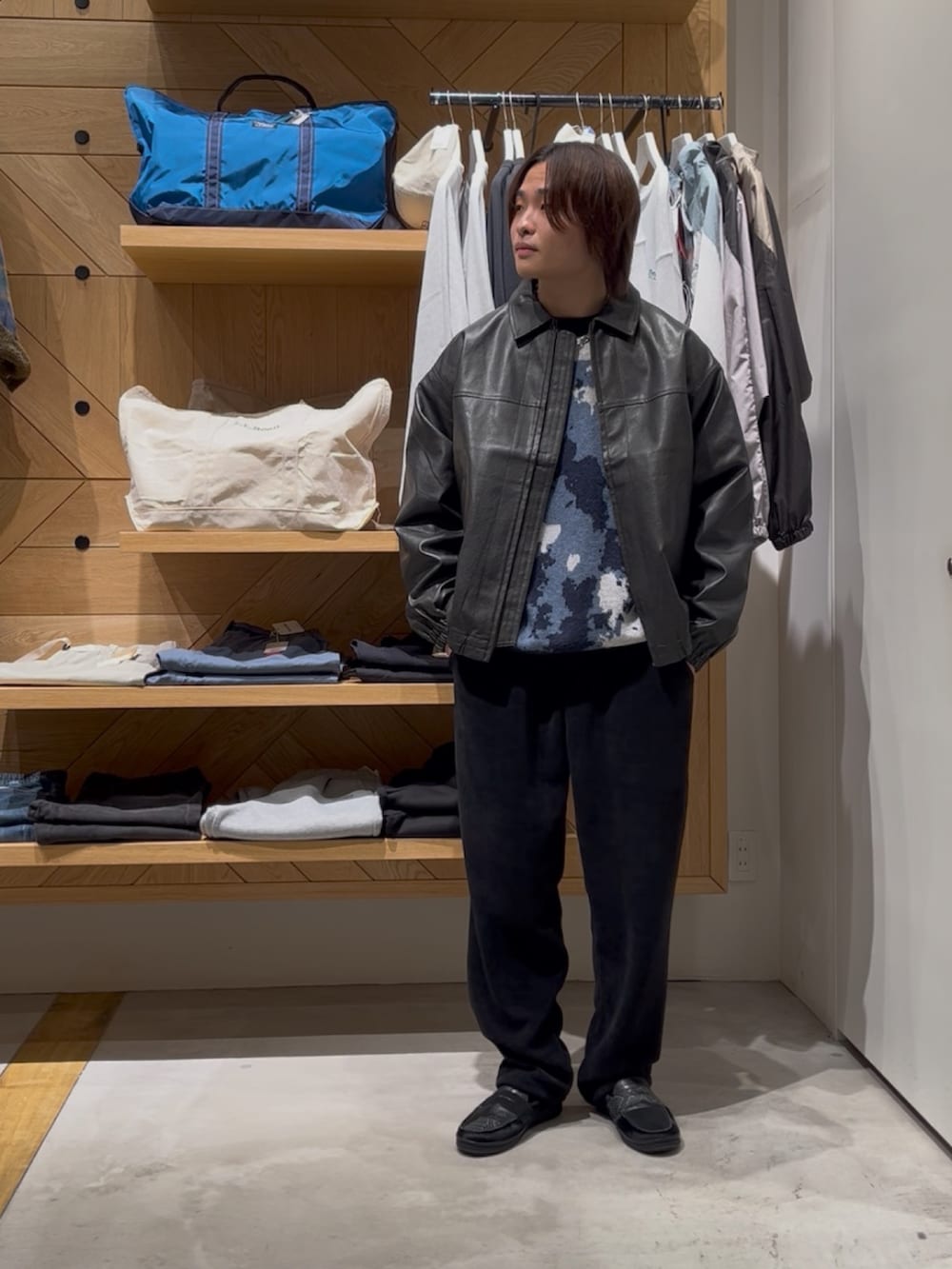 ブラック系のブルゾン、ブルー系のニット/セーター、ブラック系のその他パンツを着用したメンズの冬コーディネートの2枚目の写真