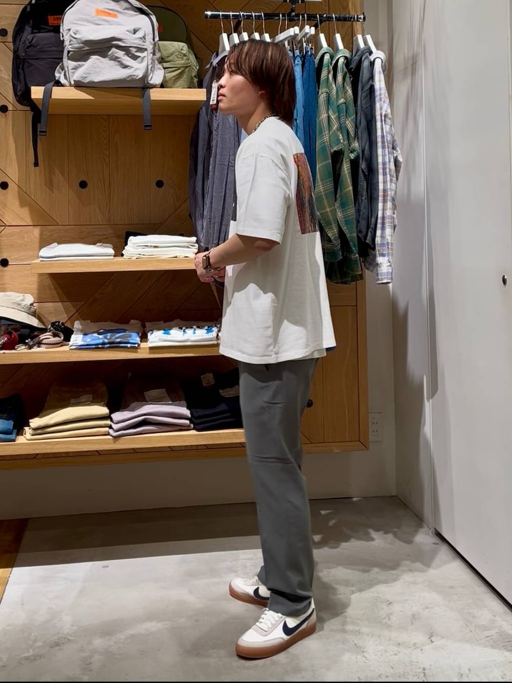 グレー系のスラックス、ホワイト系のタンクトップ、ホワイト系のTシャツ/カットソーを着用したメンズの春コーディネートの2枚目の写真