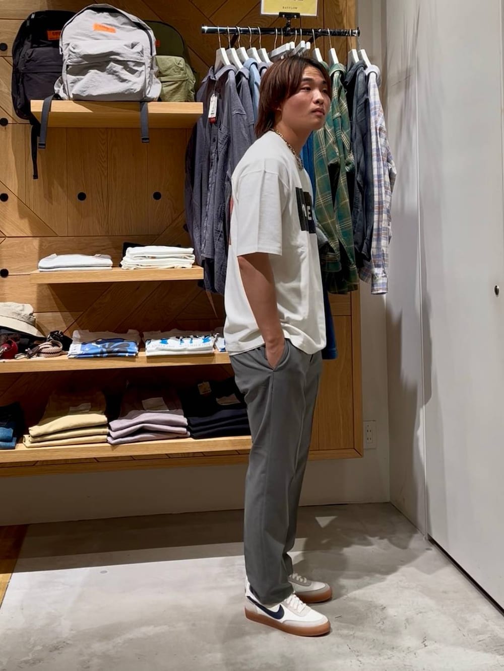 グレー系のスラックス、ホワイト系のタンクトップ、ホワイト系のTシャツ/カットソーを着用したメンズの春コーディネートの4枚目の写真