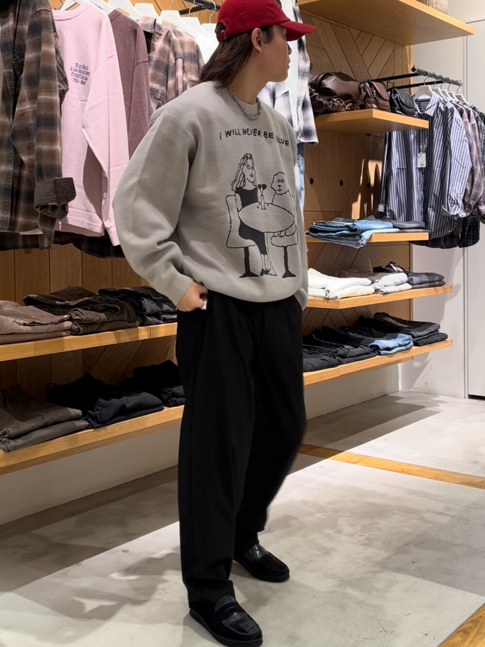 グレー系のニット/セーター、ブラック系のスラックス、ブラック系のローファーを着用したメンズの秋コーディネートの3枚目の写真