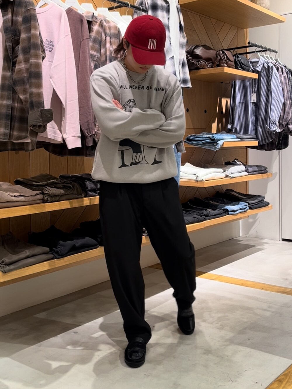 グレー系のニット/セーター、ブラック系のスラックス、ブラック系のローファーを着用したメンズの秋コーディネートの2枚目の写真