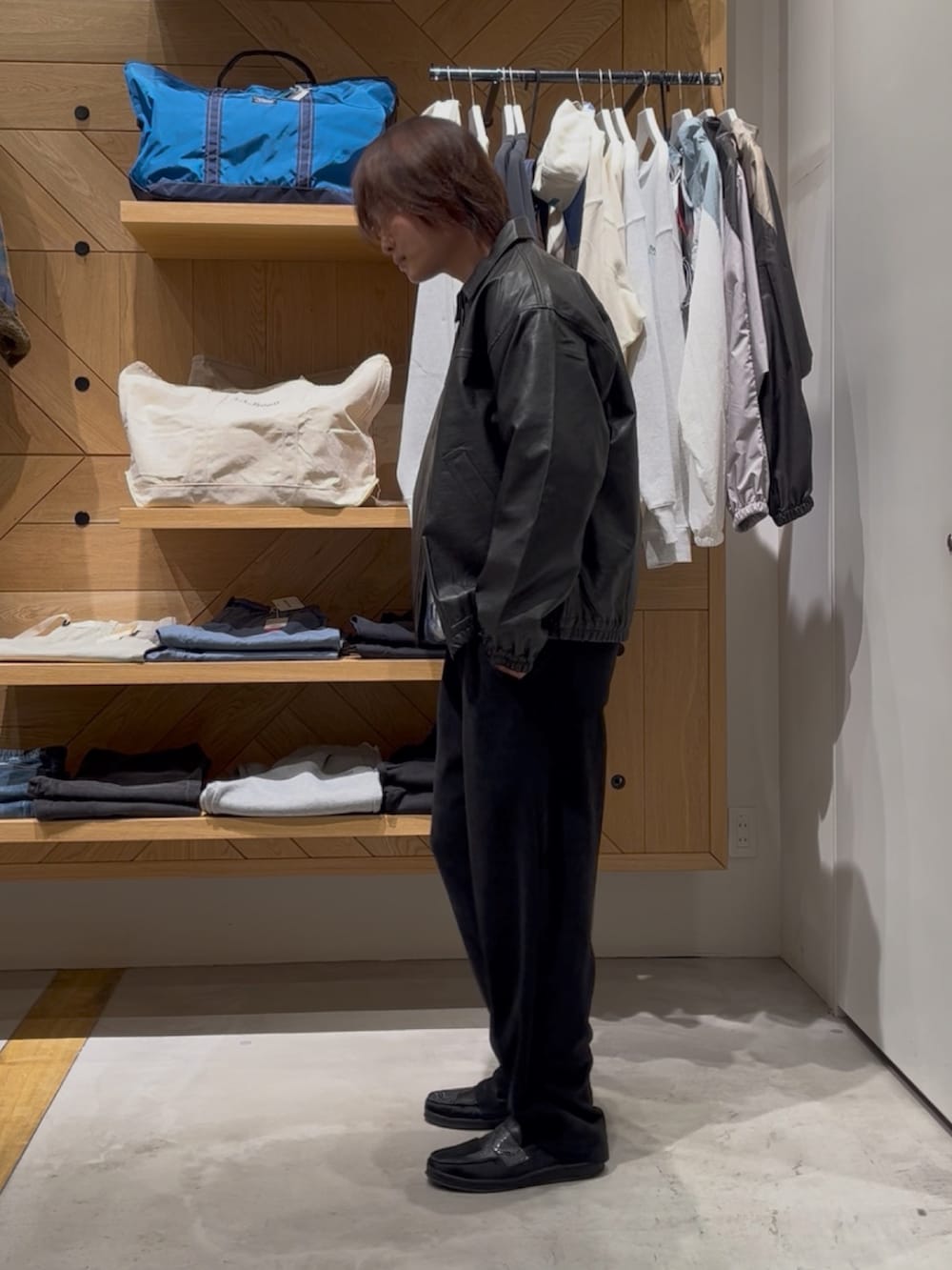 ブラック系のブルゾン、ブルー系のニット/セーター、ブラック系のその他パンツを着用したメンズの冬コーディネートの3枚目の写真