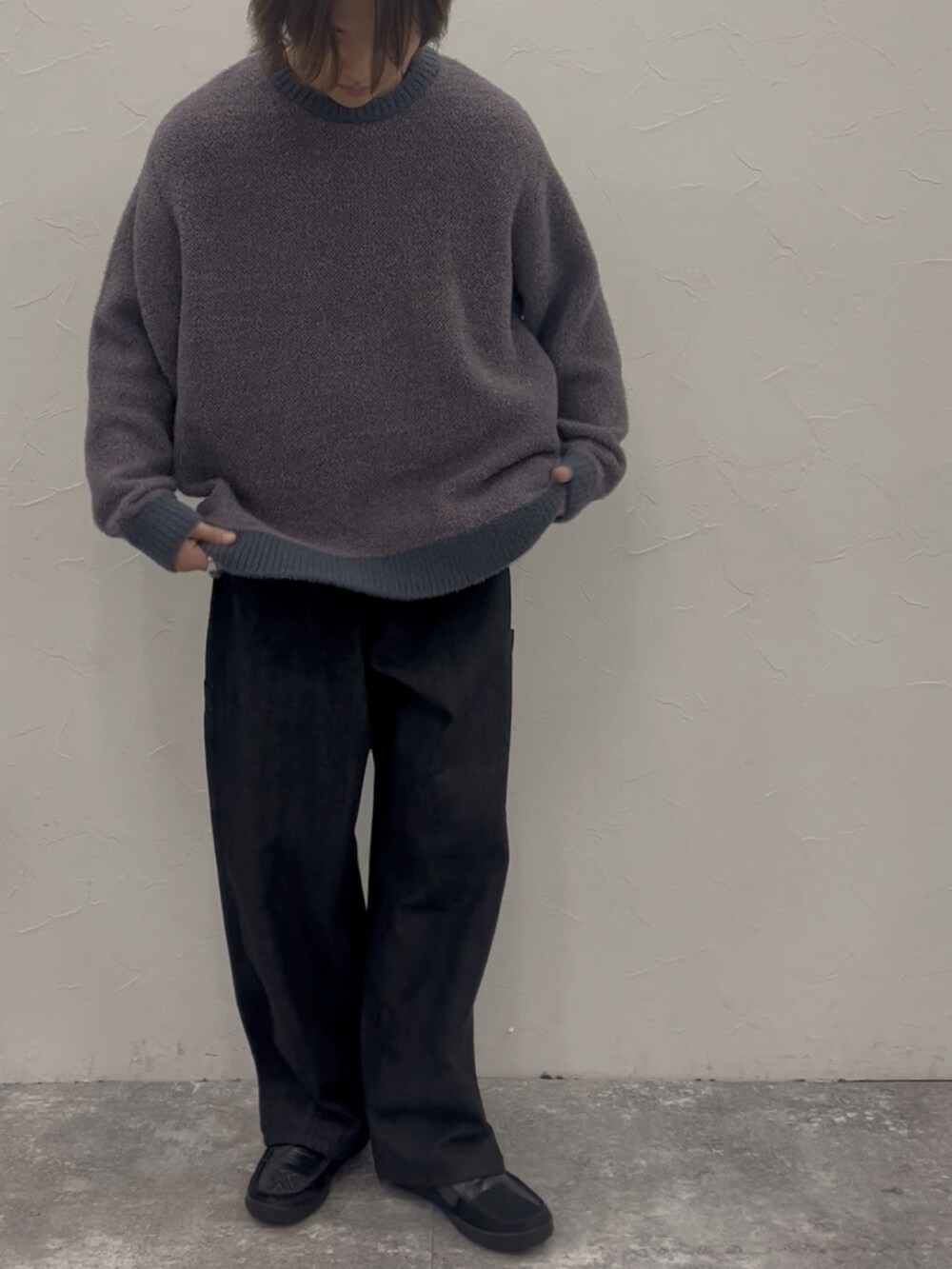 パープル系のニット/セーター、ブラック系のデニムパンツ、ブラック系のローファーを着用したメンズの秋コーディネートの2枚目の写真