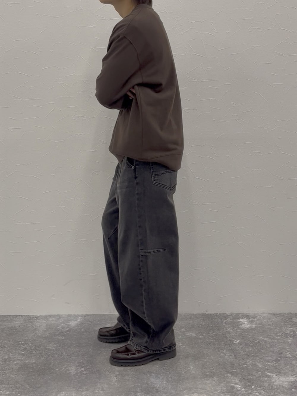 ブラウン系のスウェット、グレー系のデニムパンツ、ブラウン系のローファーを着用したメンズの秋コーディネートの3枚目の写真