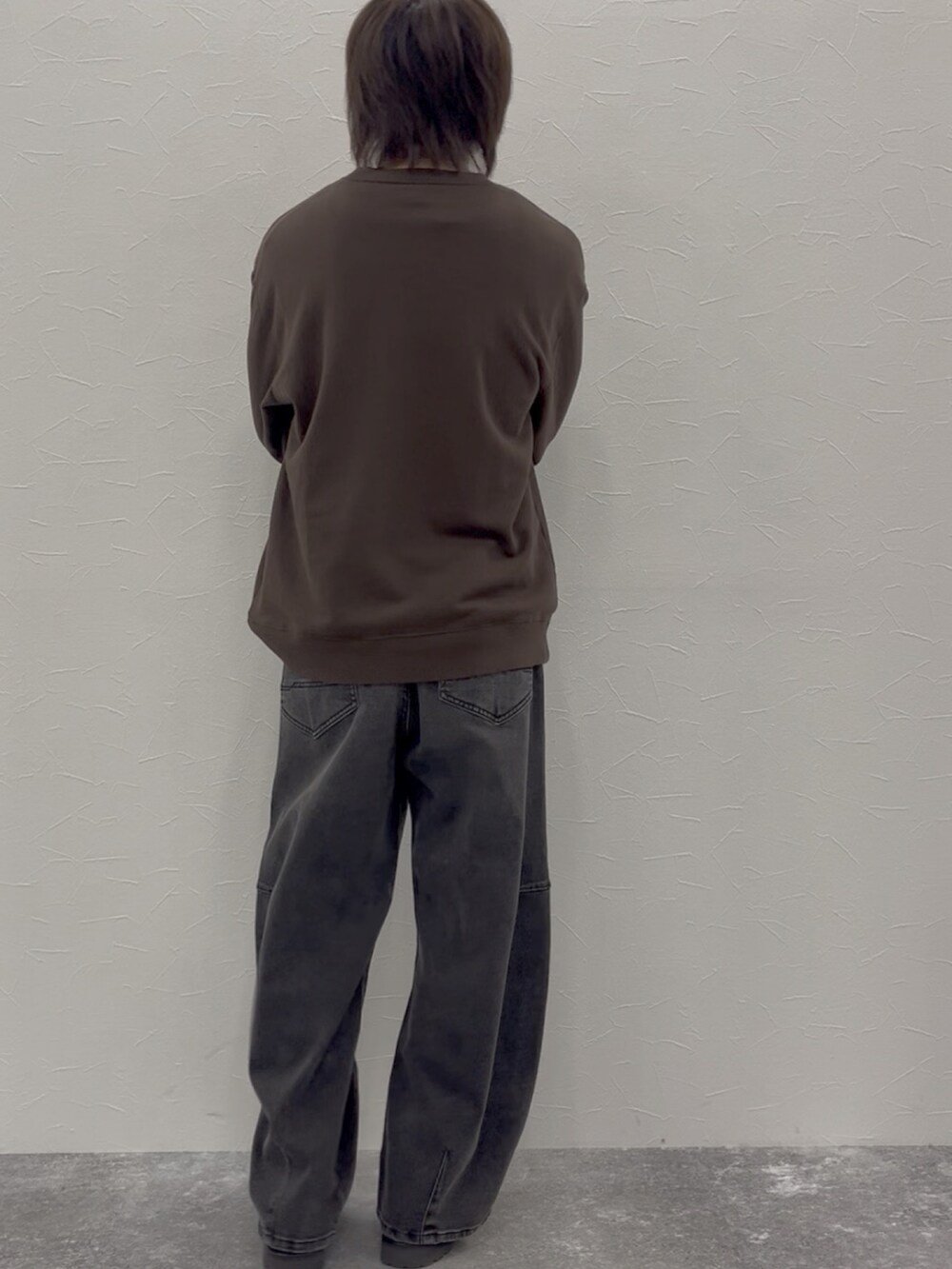 ブラウン系のスウェット、グレー系のデニムパンツ、ブラウン系のローファーを着用したメンズの秋コーディネートの4枚目の写真