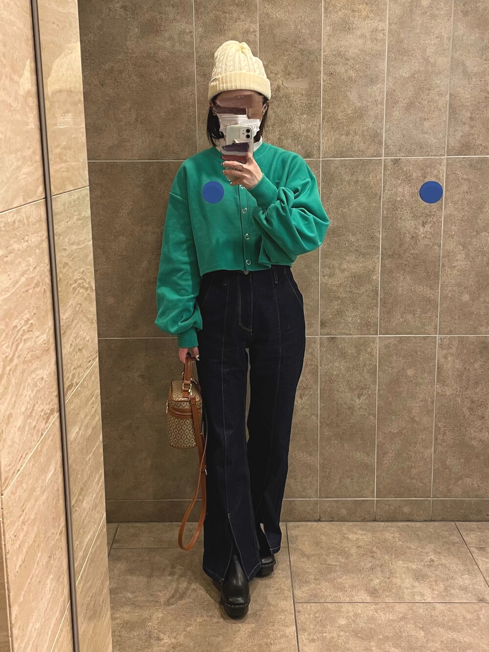 ブルー系のデニムパンツ、ブラック系のブーツ、ホワイト系のニット/セーターを着用したレディースの冬コーディネートの2枚目の写真