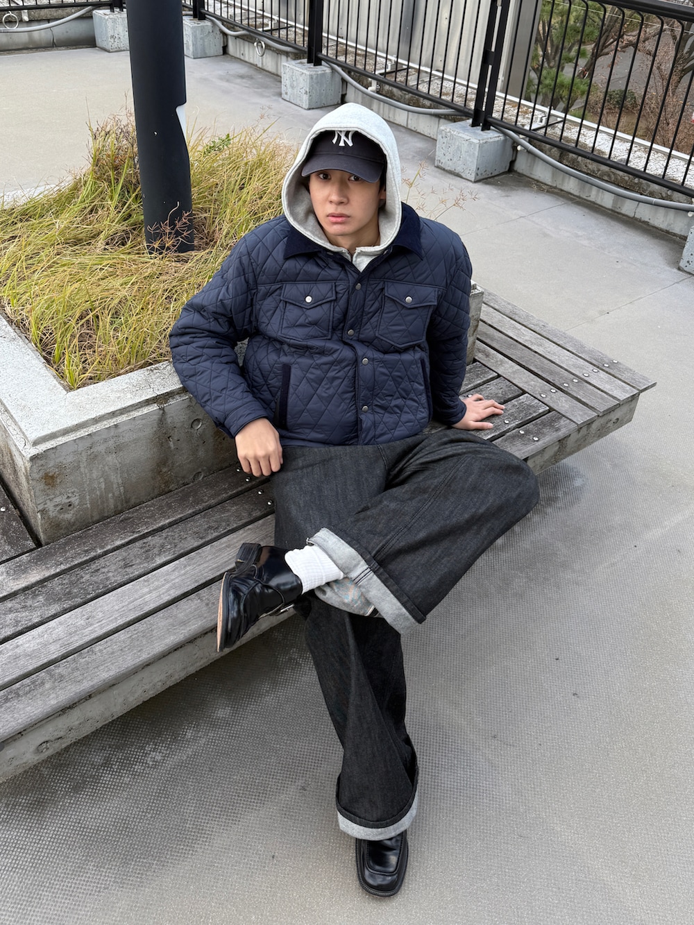 ブルー系のブルゾン、ブラック系のデニムパンツ、グレー系のパーカーを着用したメンズの冬コーディネートの2枚目の写真