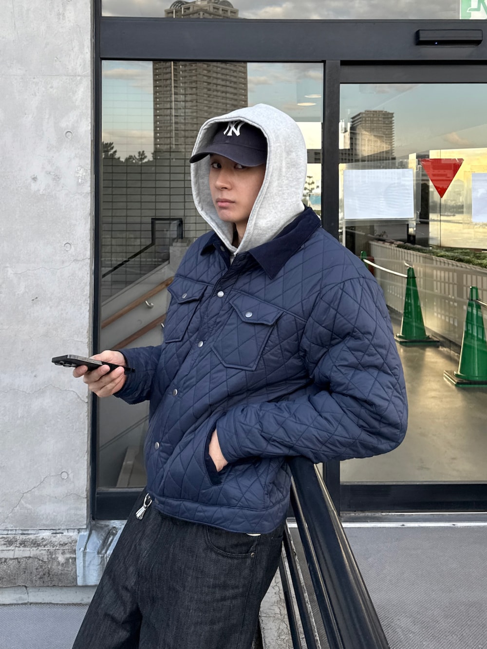 ブルー系のブルゾン、ブラック系のデニムパンツ、グレー系のパーカーを着用したメンズの冬コーディネートの3枚目の写真