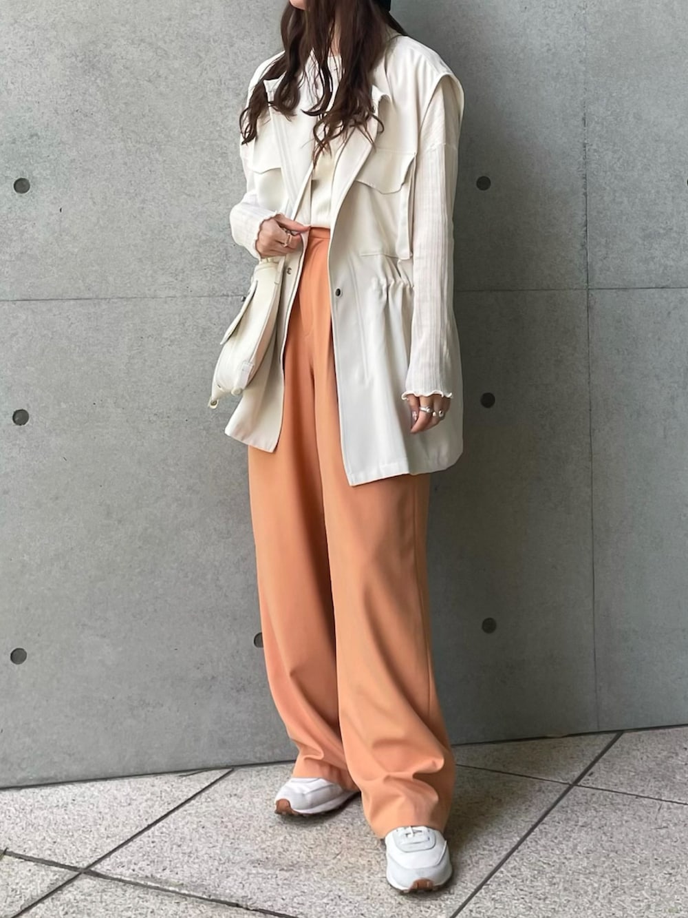 ベージュ系のTシャツ/カットソー、ホワイト系のショルダーバッグ、ホワイト系のベストを着用したレディースの春コーディネートの2枚目の写真