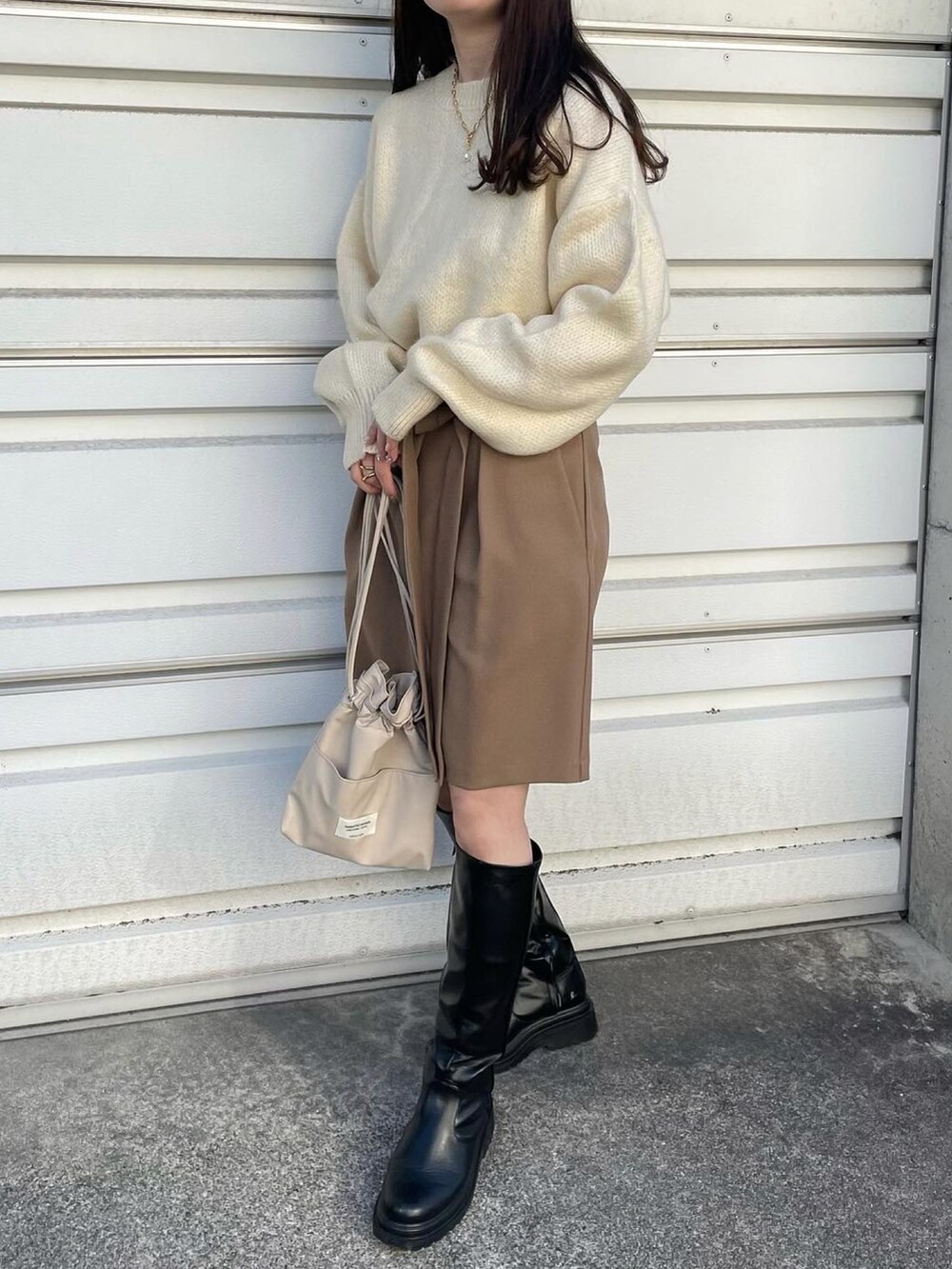 ブラウン系のベスト、ホワイト系のニット/セーター、ベージュ系のその他パンツを着用したレディースの秋コーディネートの2枚目の写真