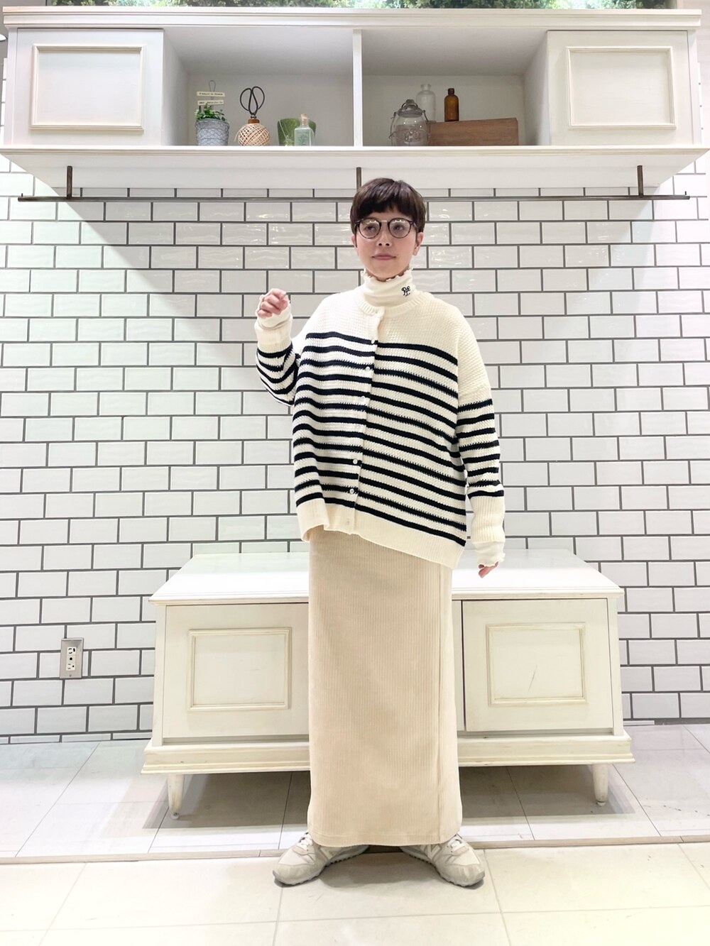 ホワイト系のTシャツ/カットソー、ホワイト系のカーディガン/ボレロ、ホワイト系のスカートを着用したレディースの冬コーディネートの2枚目の写真