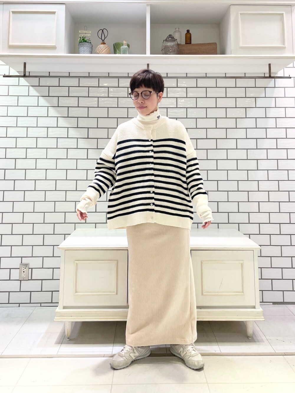 ホワイト系のTシャツ/カットソー、ホワイト系のカーディガン/ボレロ、ホワイト系のスカートを着用したレディースの冬コーディネートの3枚目の写真