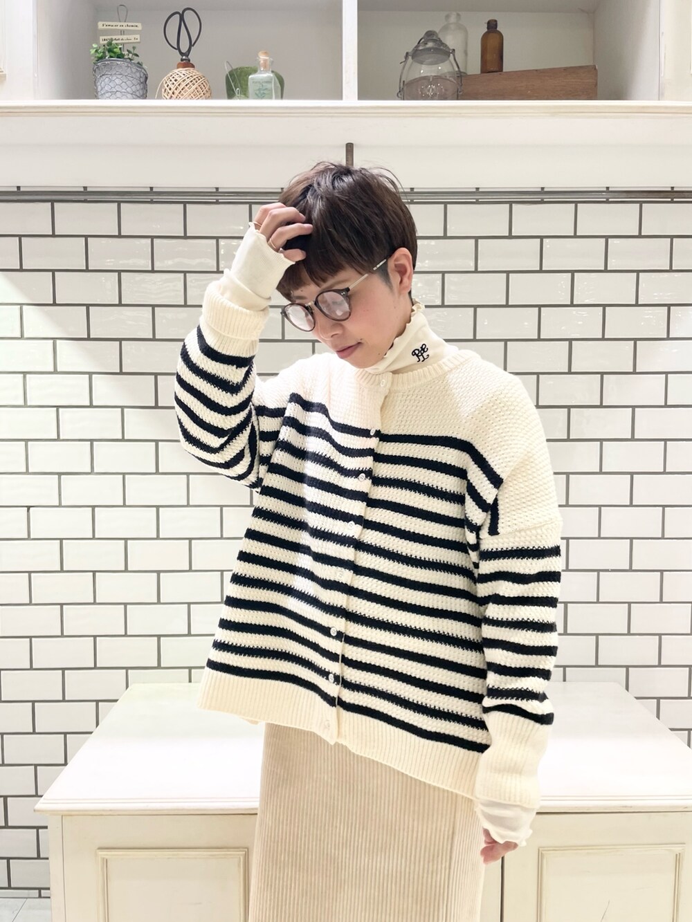 ホワイト系のTシャツ/カットソー、ホワイト系のカーディガン/ボレロ、ホワイト系のスカートを着用したレディースの冬コーディネートの6枚目の写真