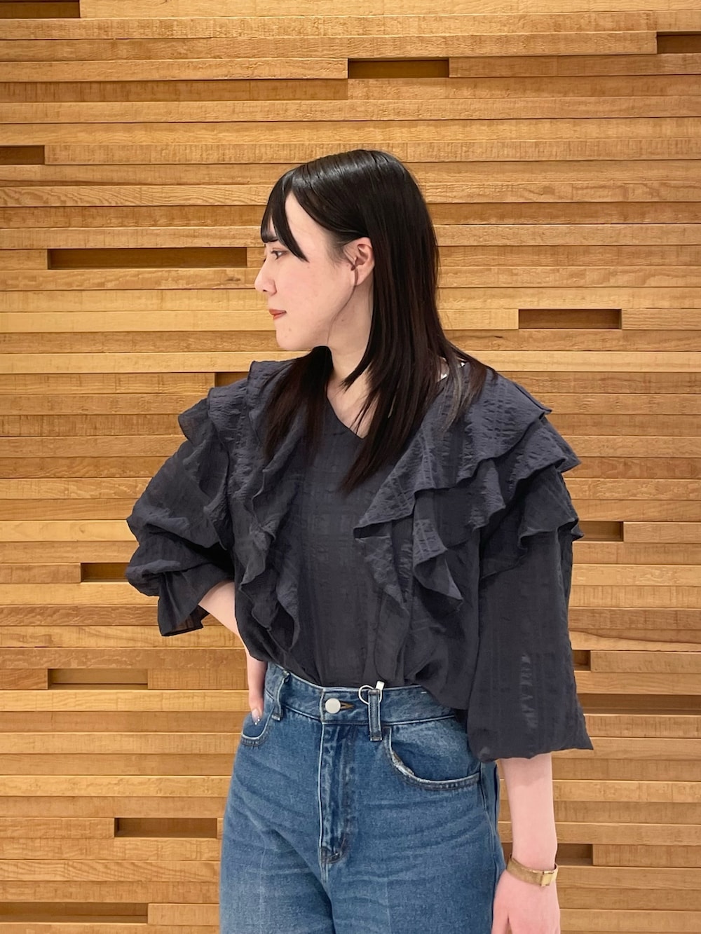 ブラック系のブーツ、ブラック系のシャツ/ブラウス、ブルー系のデニムパンツを着用したレディースの春コーディネートの3枚目の写真