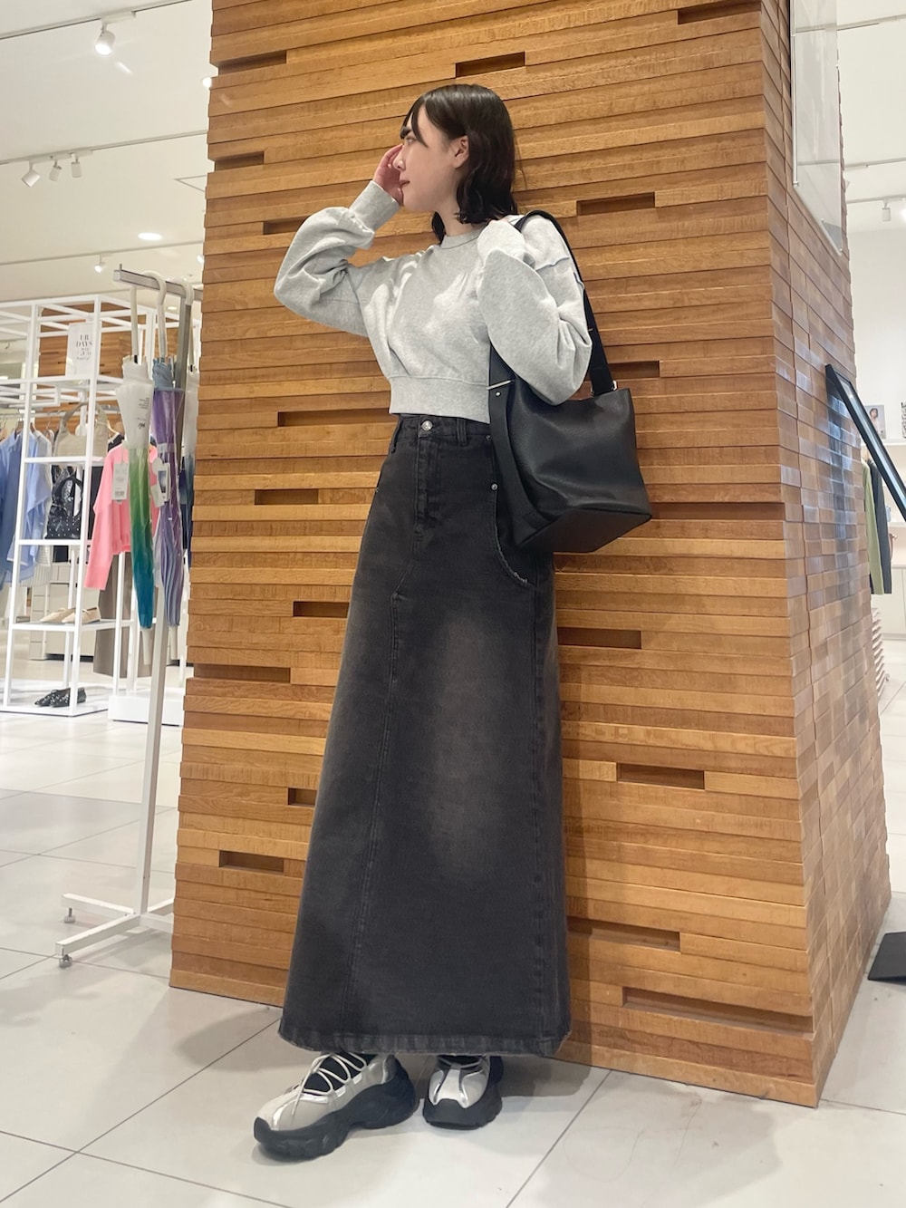 ブラック系のスカート、グレー系のスニーカー、グレー系のスウェットを着用したレディースの春コーディネートの2枚目の写真