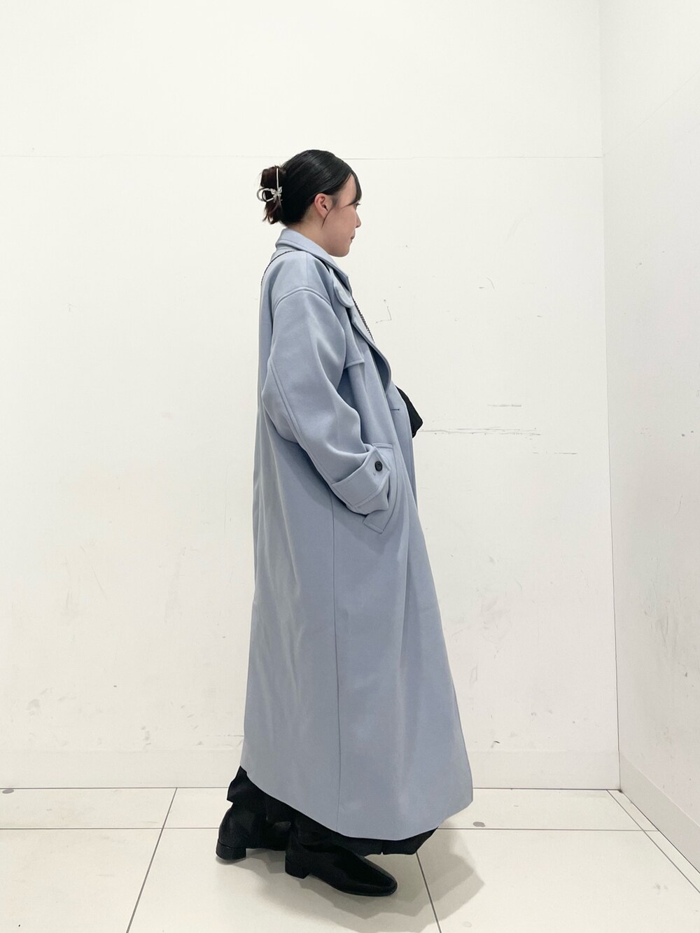 ブラック系のブーツ、ブラック系のスカート、ブルー系のニット/セーターを着用したレディースの秋コーディネートの2枚目の写真