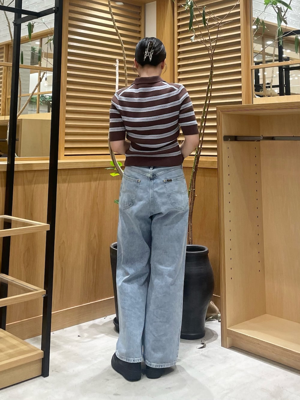 ブラウン系のニット/セーター、シルバー系のショルダーバッグ、ブルー系のデニムパンツを着用したレディースの夏コーディネートの3枚目の写真