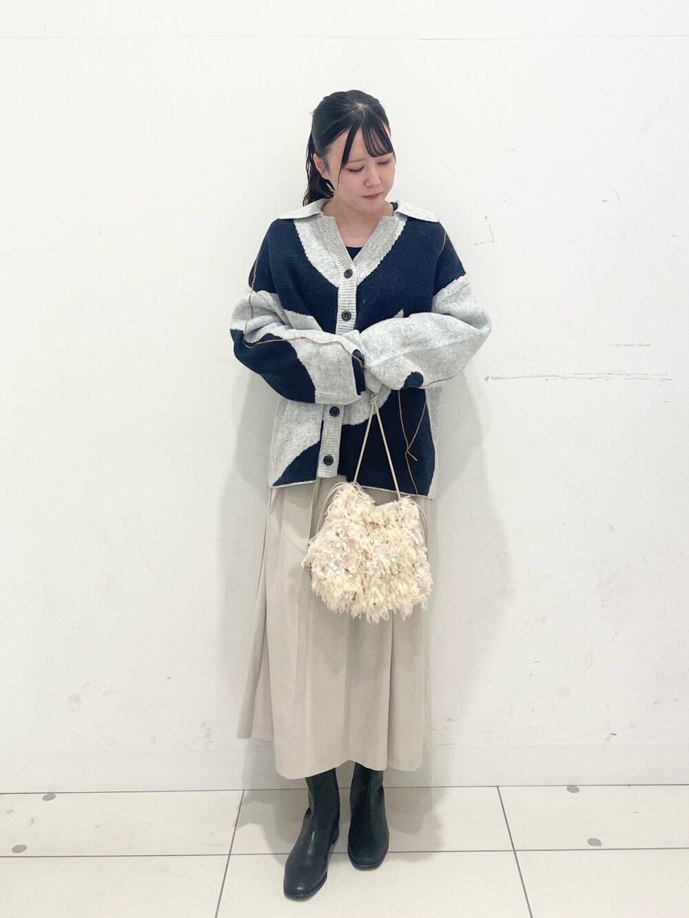 ブルー系のTシャツ/カットソー、ホワイト系のカーディガン/ボレロ、ベージュ系のスカートを着用したレディースの秋コーディネートの2枚目の写真