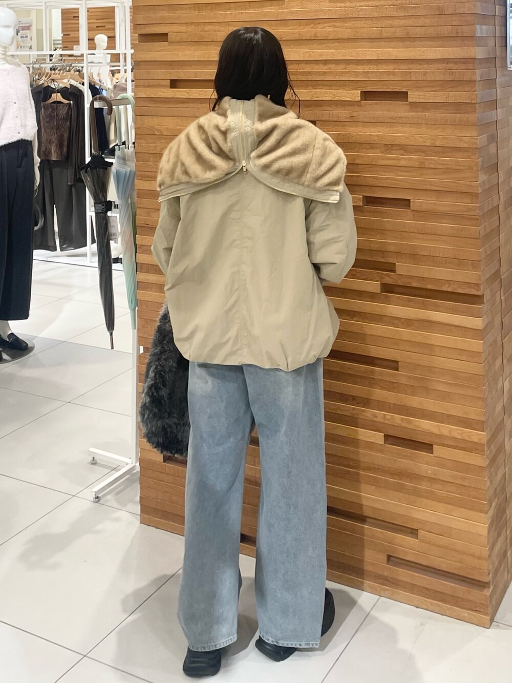 グレー系のトートバッグ、ブルー系のデニムパンツ、ブラック系のローファーを着用したレディースの秋コーディネートの4枚目の写真