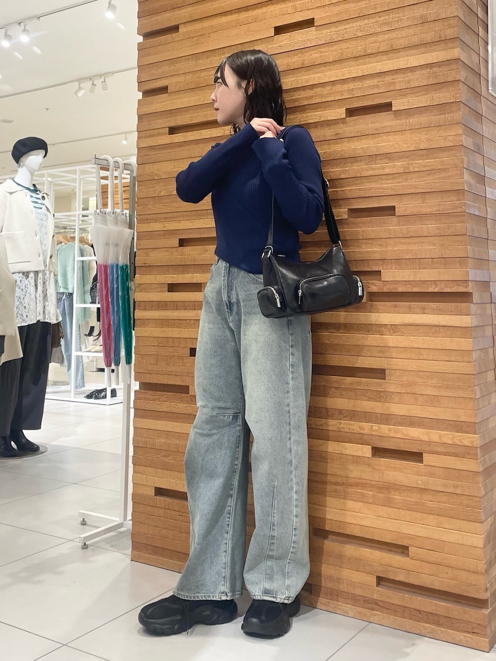 ブラック系のスニーカー、ブルー系のデニムパンツ、ブルー系のニット/セーターを着用したレディースの冬コーディネートの2枚目の写真