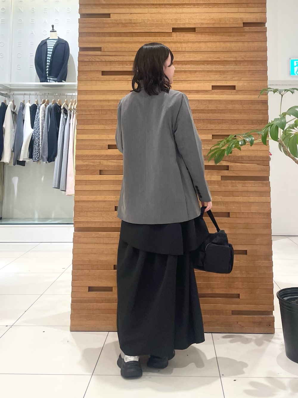 グレー系のスニーカー、ブラック系のスカート、グレー系のテーラードジャケットを着用したレディースの春コーディネートの4枚目の写真