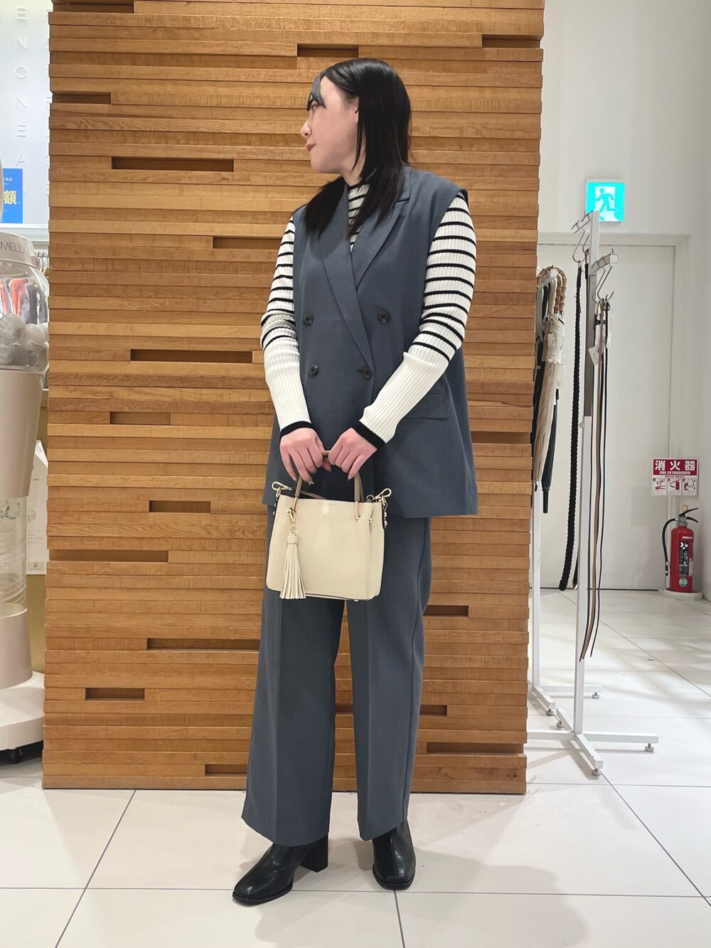 ブルー系のその他パンツ、ホワイト系のニット/セーター、ブラック系のブーツを着用したレディースの春コーディネートの2枚目の写真