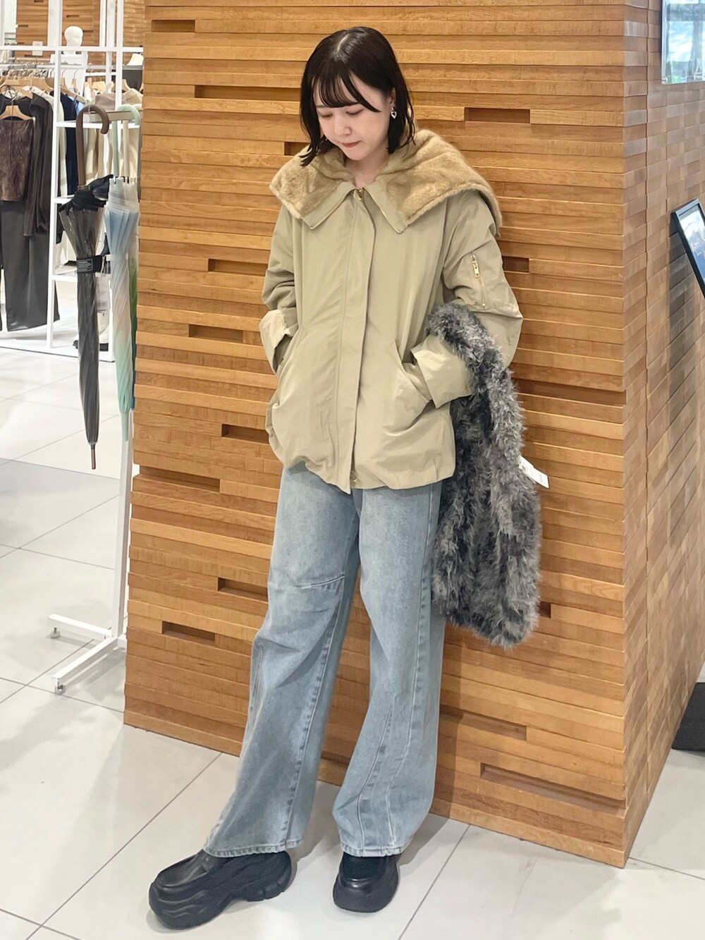グレー系のトートバッグ、ブルー系のデニムパンツ、ブラック系のローファーを着用したレディースの秋コーディネートの2枚目の写真